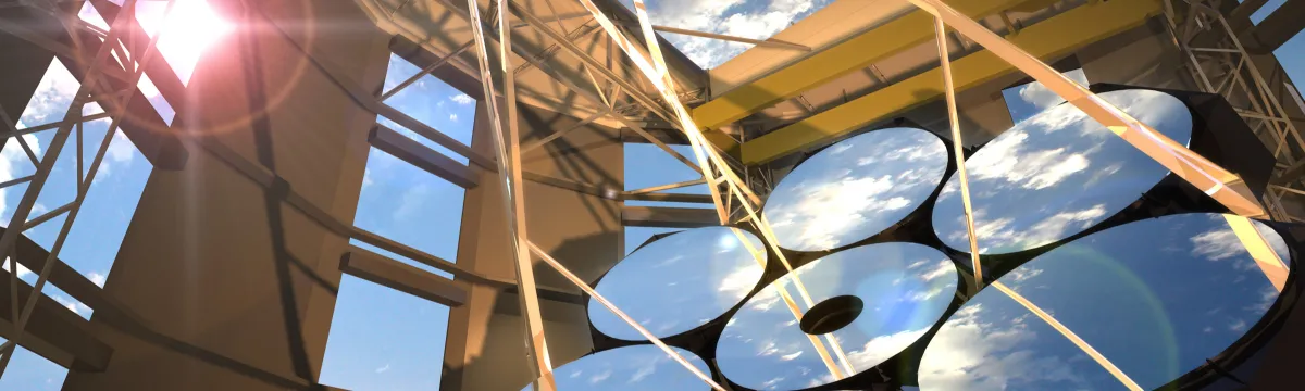 A large telescope under a bright sun with its mirrors reflecting the blue sky and clouds, set against a steel structure.